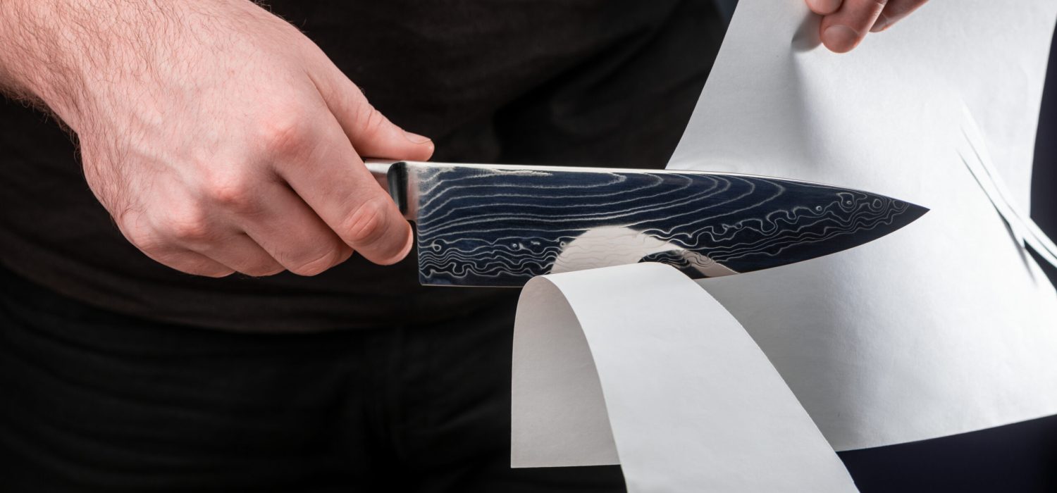 Man,Testing,Sharpness,Of,Knife,By,Cutting,A,Thin,Sheet